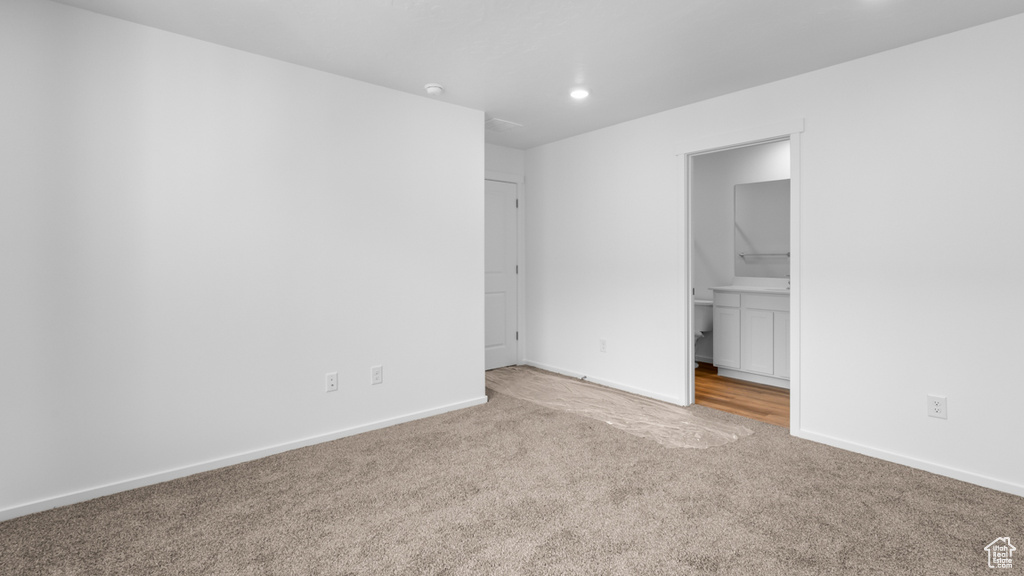 Unfurnished bedroom featuring carpet, recessed lighting, baseboards, and ensuite bath