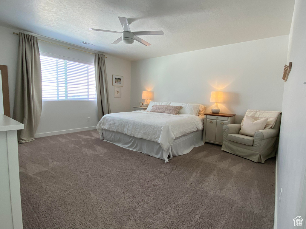 Bedroom featuring carpet, baseboards, ceiling fan, and a textured ceiling