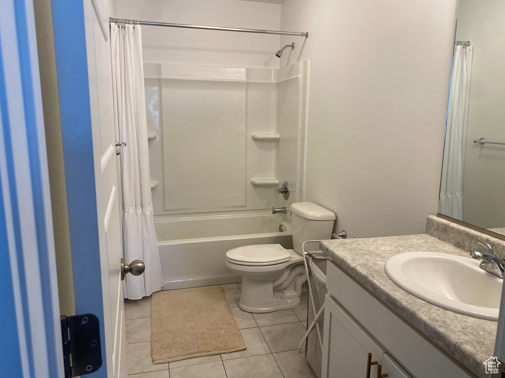 Full bathroom featuring vanity, tile patterned flooring, shower / tub combo with curtain, and toilet