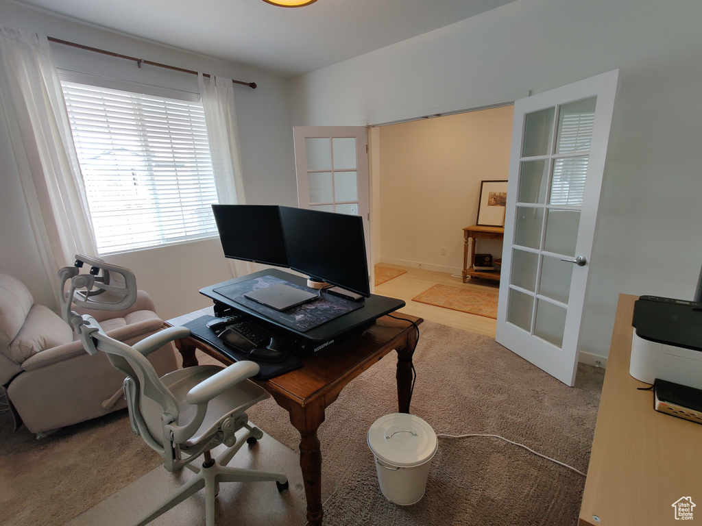 Carpeted home office featuring french doors
