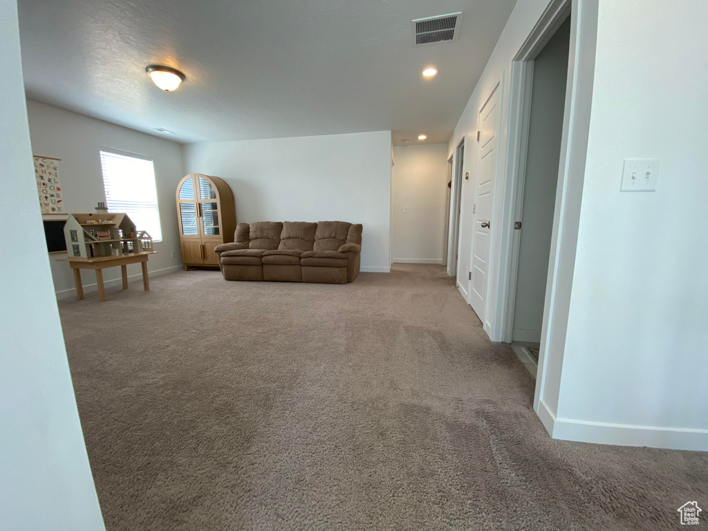 Carpeted living area with baseboards and recessed lighting