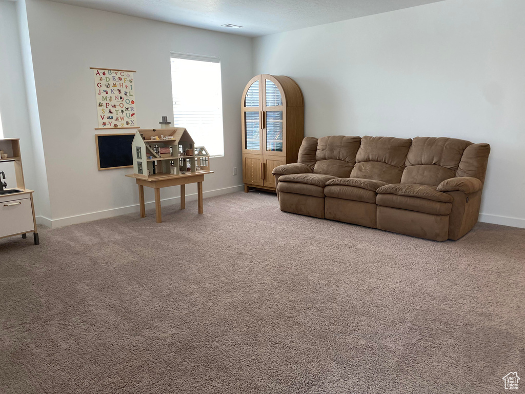 Carpeted living area featuring baseboards