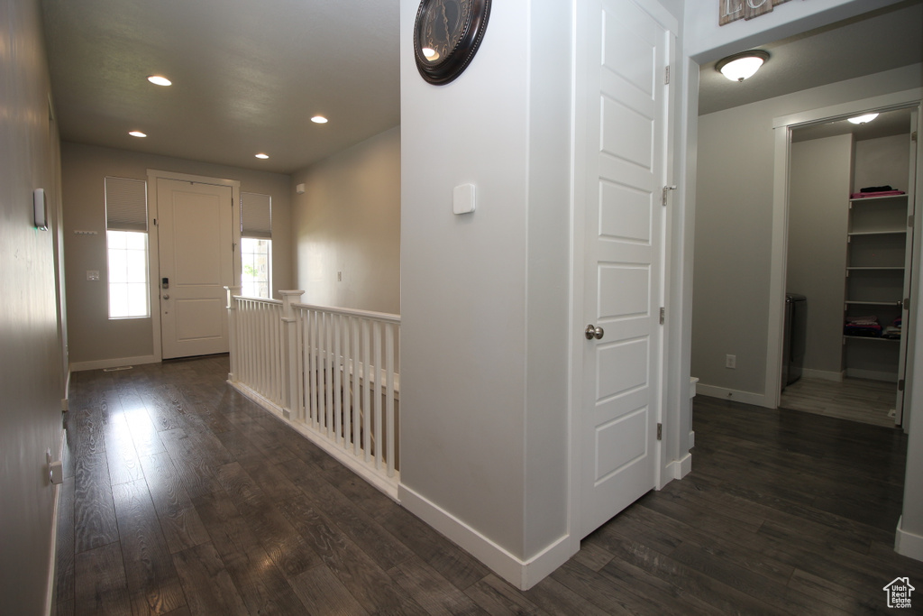 Hallway with dark wood-style flooring, recessed lighting, and baseboards