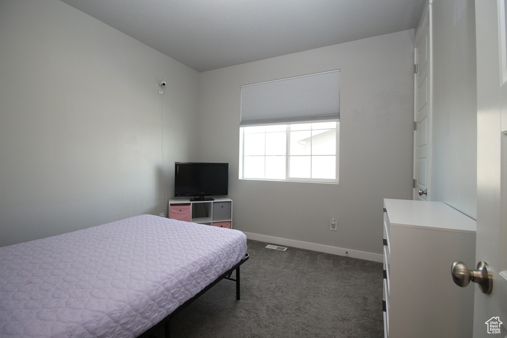 Bedroom with dark colored carpet and baseboards