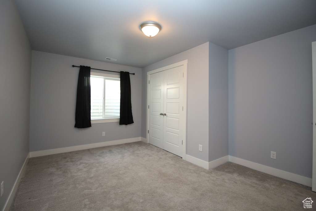 Unfurnished bedroom with carpet flooring, baseboards, and a closet