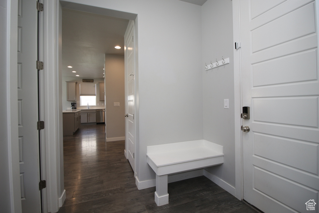 Mudroom featuring dark wood finished floors, baseboards, recessed lighting, and a sink