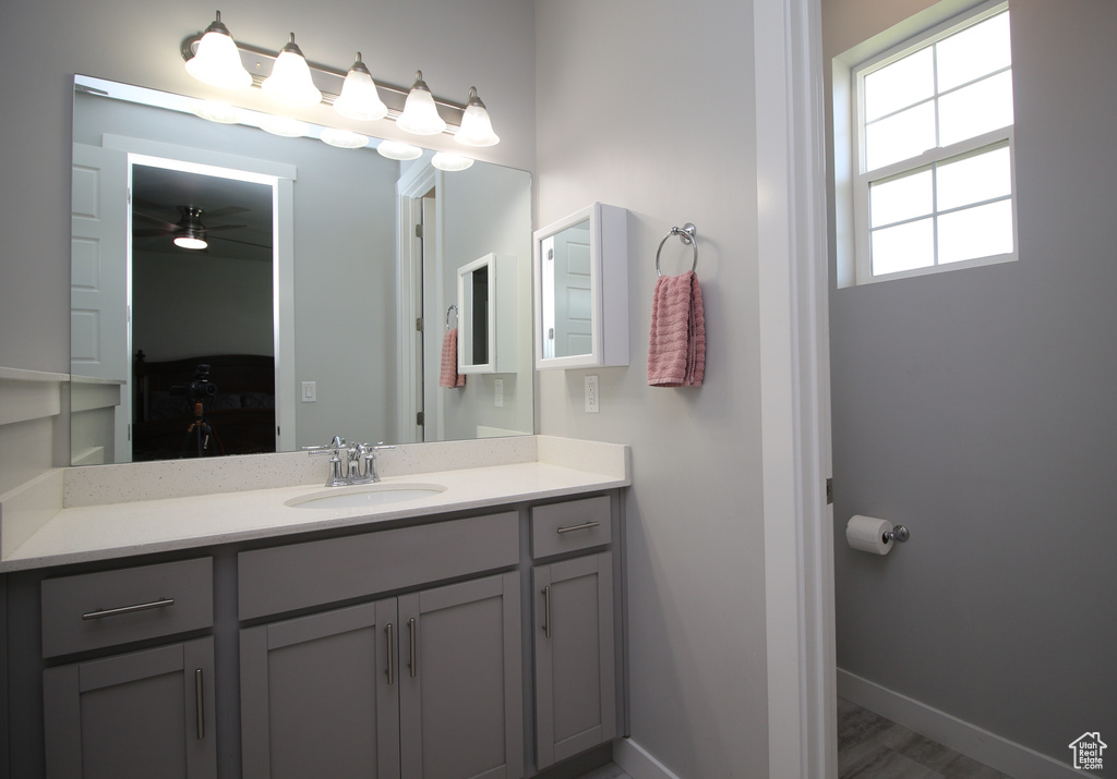 Bathroom featuring vanity, baseboards, and a ceiling fan