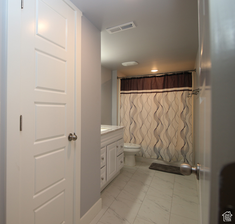 Full bath featuring marble finish floors, vanity, toilet, and a shower with curtain