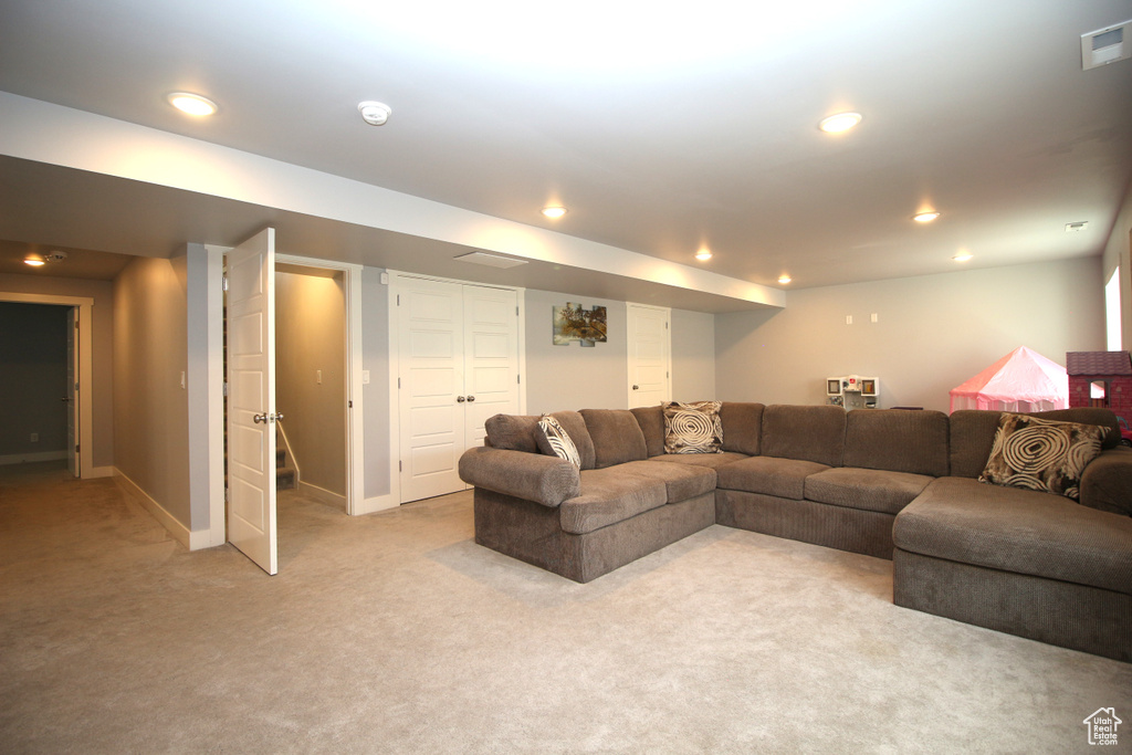 Living area featuring light carpet, baseboards, and recessed lighting