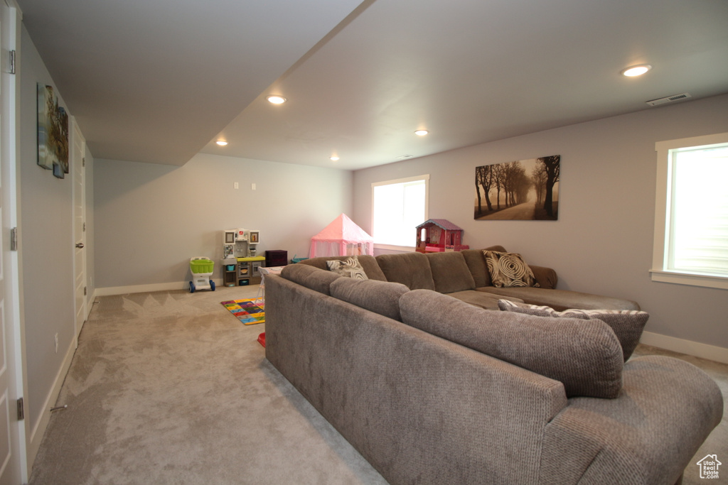 Living room featuring baseboards, light carpet, and recessed lighting