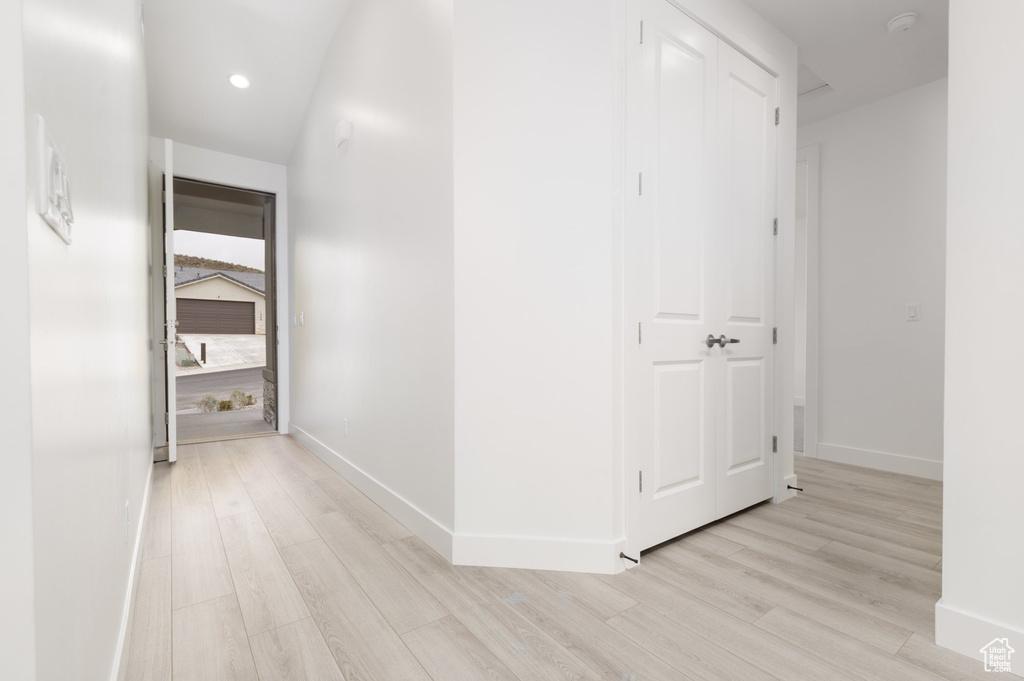 Hallway with light wood-style floors, baseboards, and recessed lighting