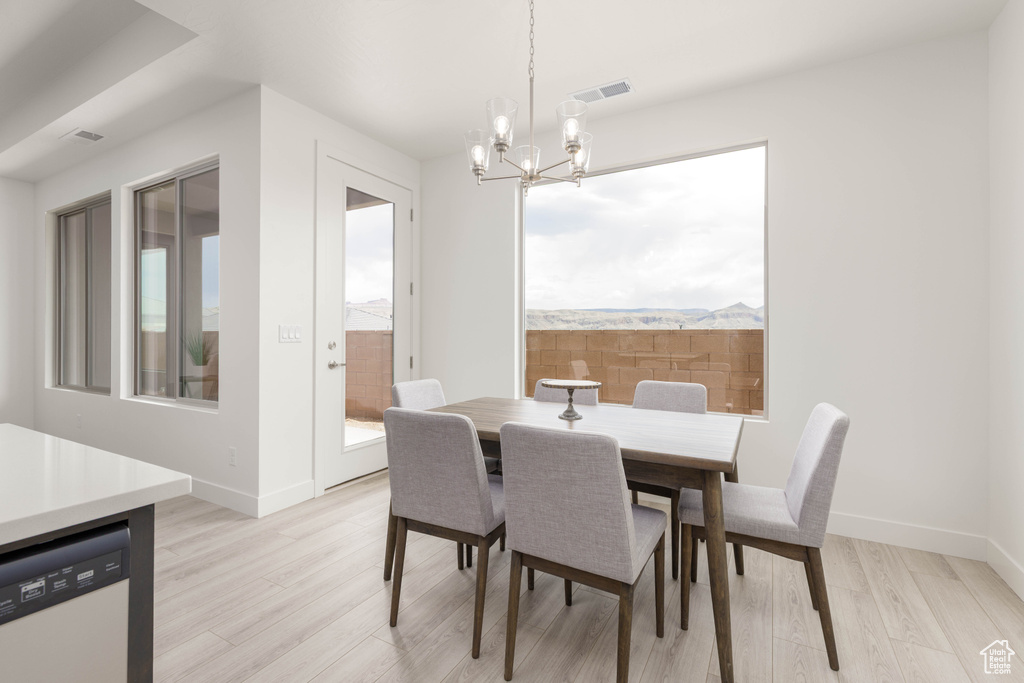 Dining space featuring a chandelier, light wood-style floors, and baseboards