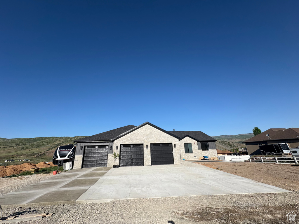 View of front of house featuring a garage, driveway, and a mountain view