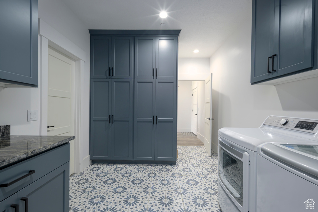 Washroom with washing machine and dryer, cabinet space, and recessed lighting