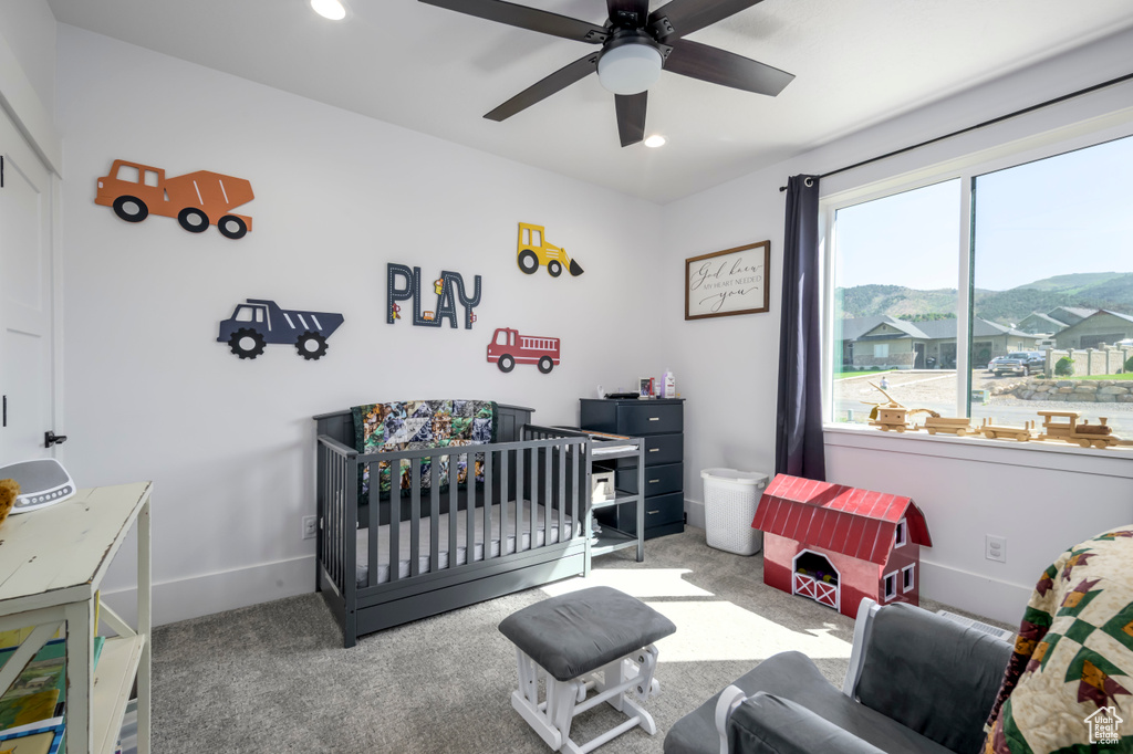 Carpeted bedroom featuring baseboards, a nursery area, a mountain view, recessed lighting, and a ceiling fan