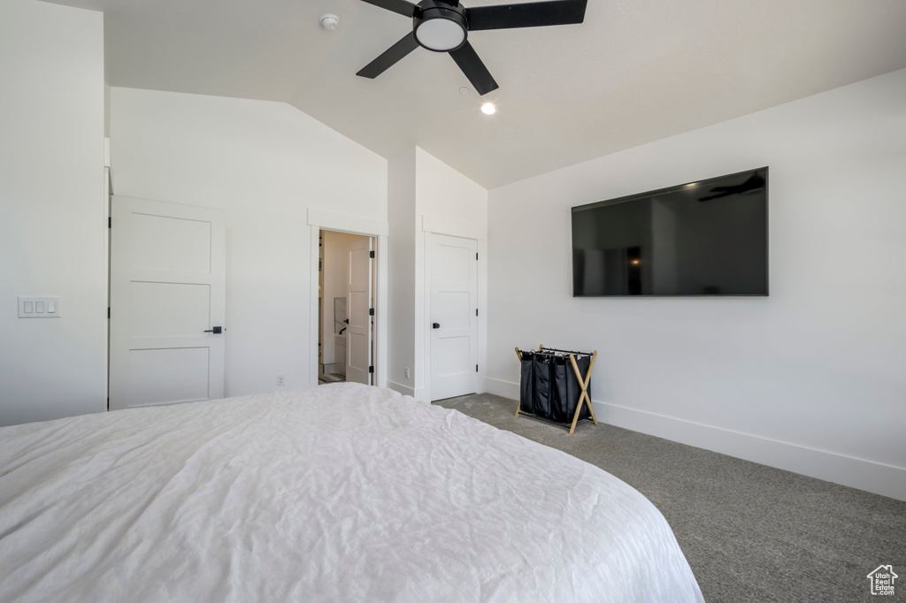Carpeted bedroom featuring vaulted ceiling, baseboards, and a ceiling fan