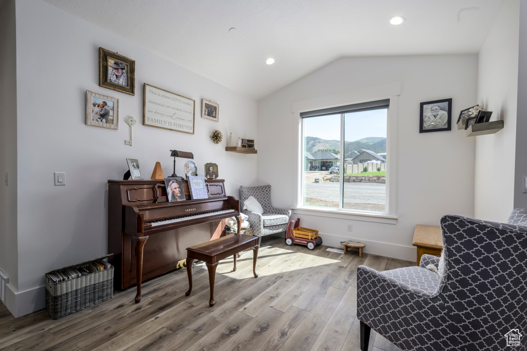 Living area featuring wood finished floors, recessed lighting, lofted ceiling, and baseboards