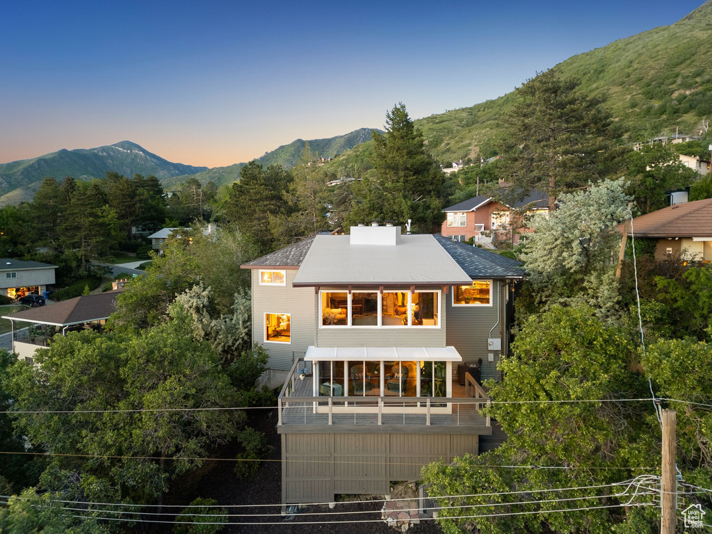 Back of property at dusk featuring a mountain view