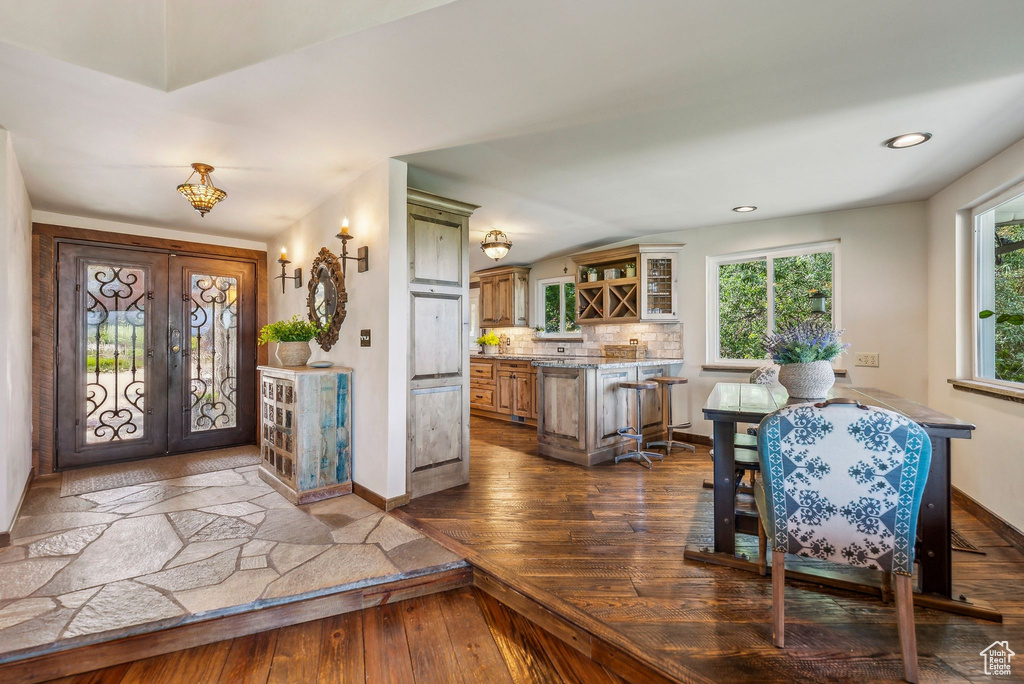 Foyer featuring dark wood-type flooring, french doors, baseboards, and recessed lighting