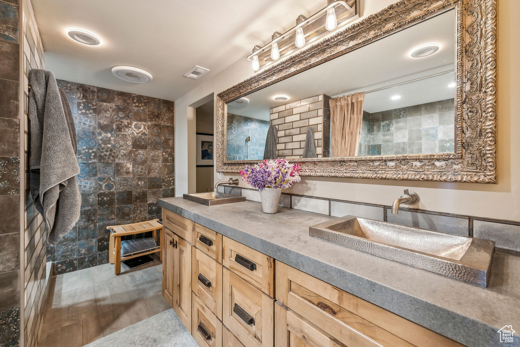 Full bathroom with double vanity and a tile shower