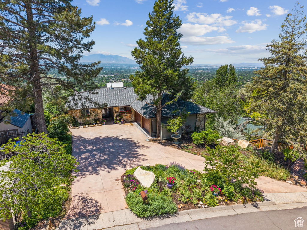 View of front of property with concrete driveway, an attached garage, and a mountain view