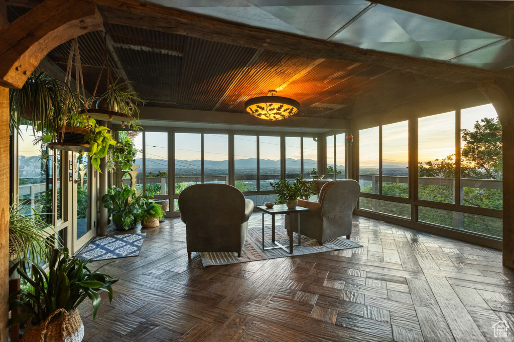 Sunroom featuring a water and mountain view