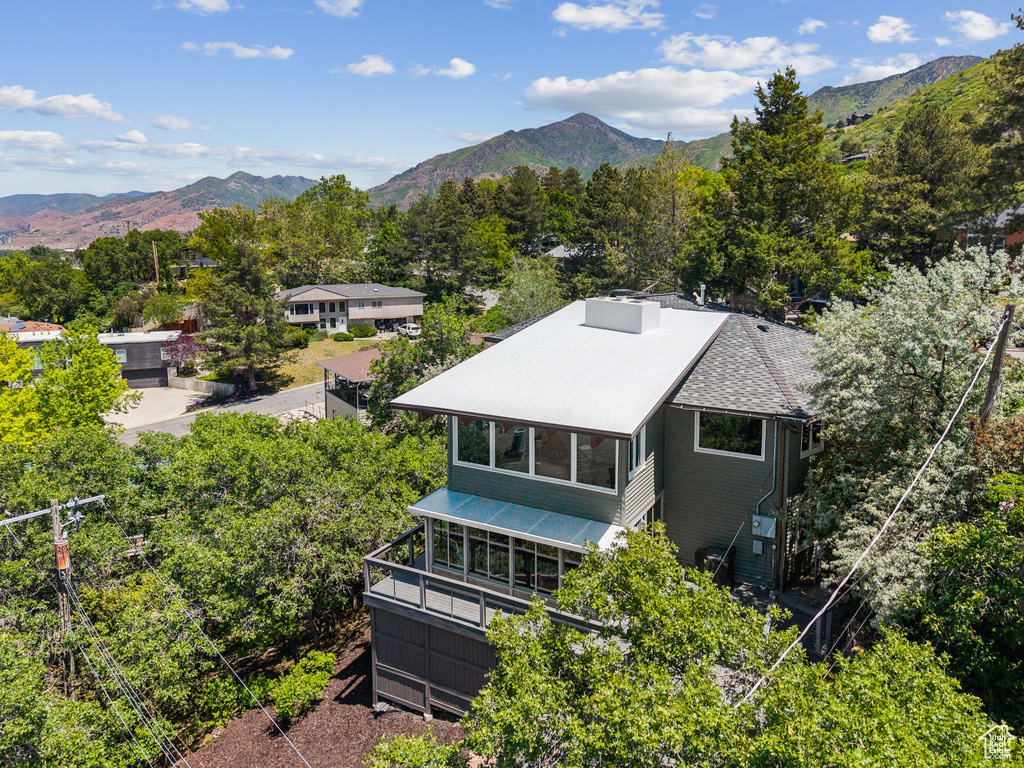 Aerial view of property and surrounding area featuring a mountain backdrop