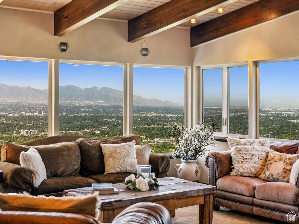 Sunroom featuring a mountain view and wood ceiling with exposed beams