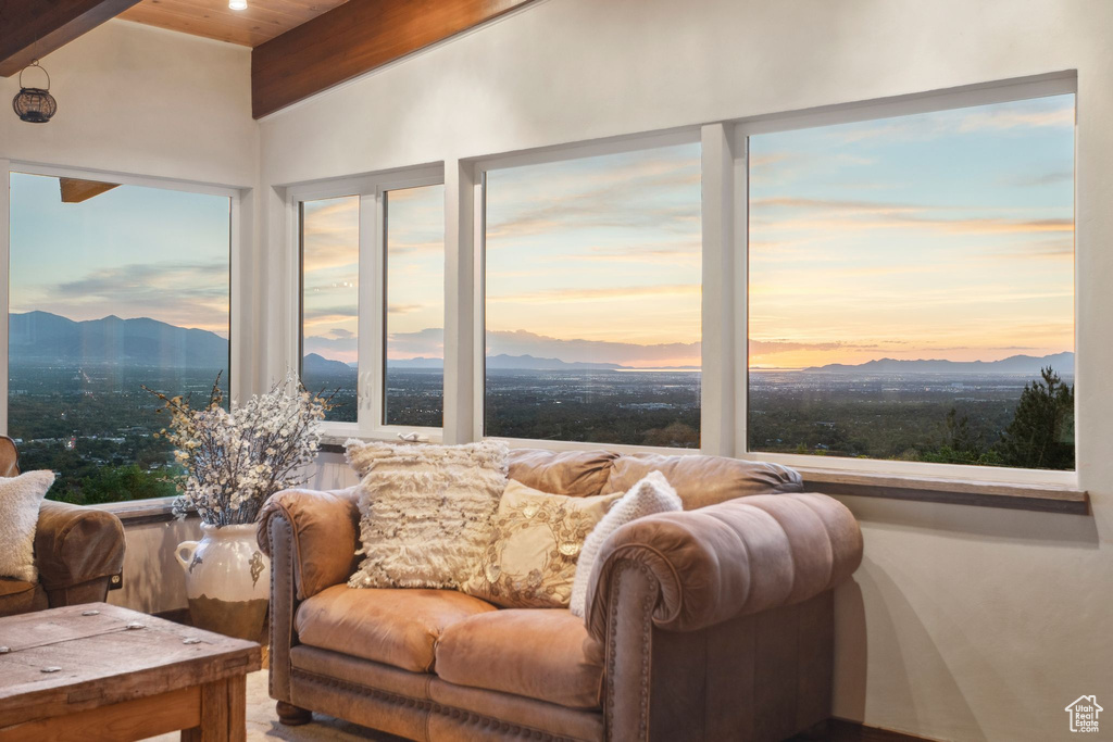 Sunroom / solarium featuring wood ceiling with exposed beams and a mountain view