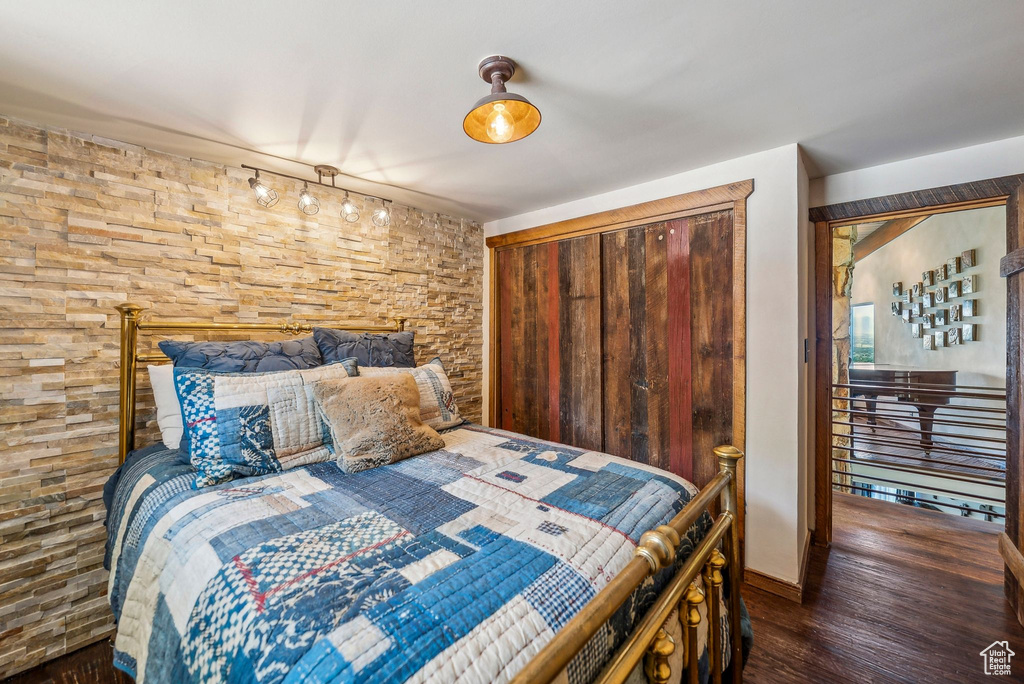 Bedroom featuring wood finished floors, a closet, and baseboards