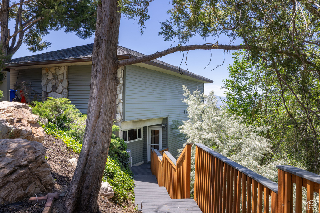 Back of property with stone siding and a deck