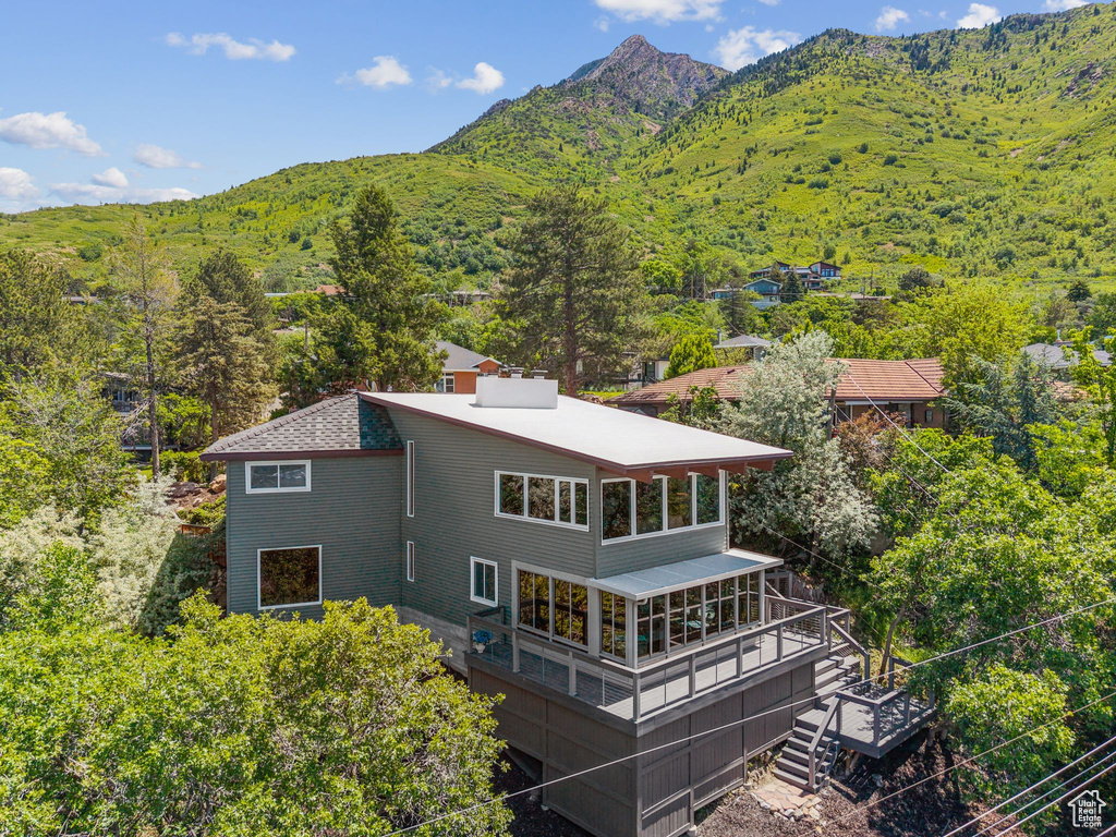 Back of house featuring stairway, a mountain view, and a forest view