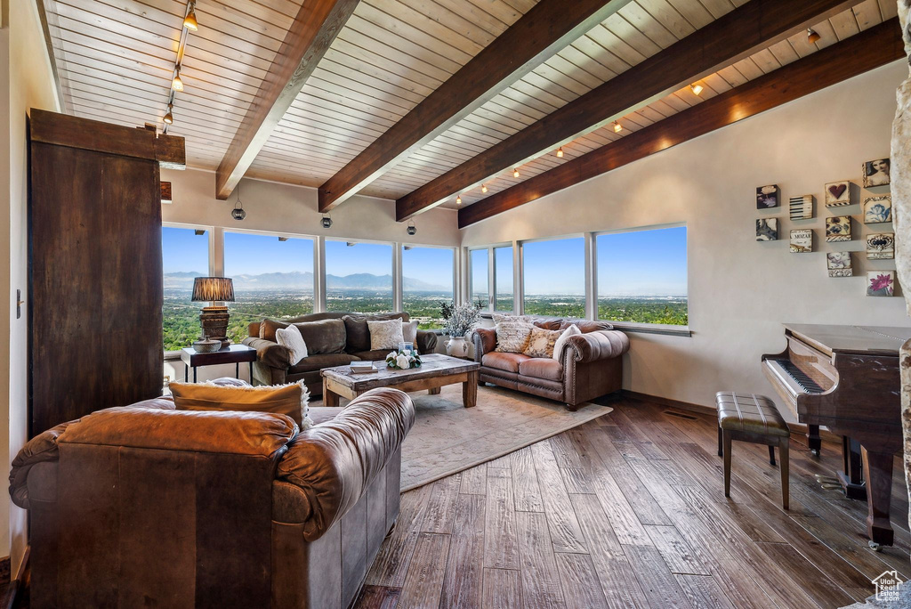 Living room featuring hardwood / wood-style flooring, wood ceiling with exposed beams, and a mountain view