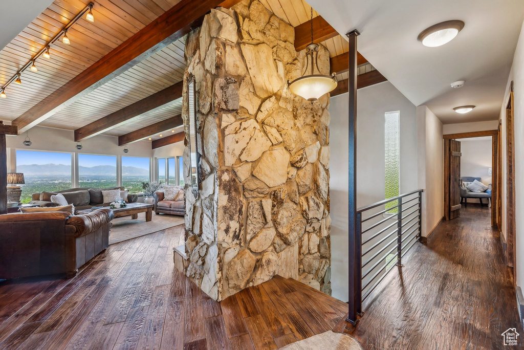 Hallway with hardwood / wood-style flooring, rail lighting, wood ceiling, a mountain view, and an upstairs landing