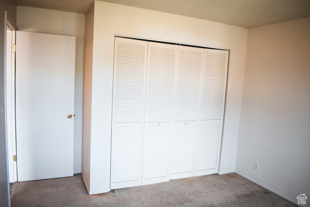 Unfurnished bedroom featuring carpet and a closet