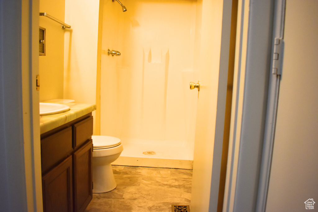 Full bath with vanity, toilet, and a stall shower