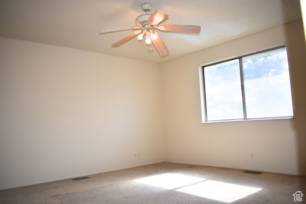 Carpeted empty room with a ceiling fan