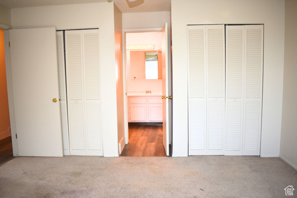 Unfurnished bedroom featuring two closets and carpet floors