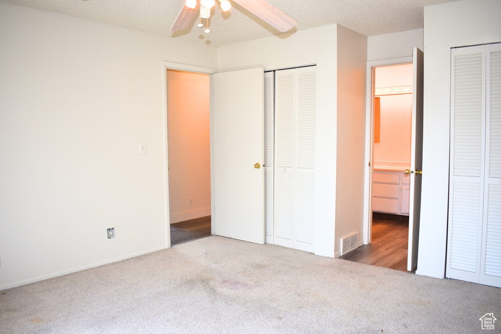 Unfurnished bedroom with carpet floors and two closets