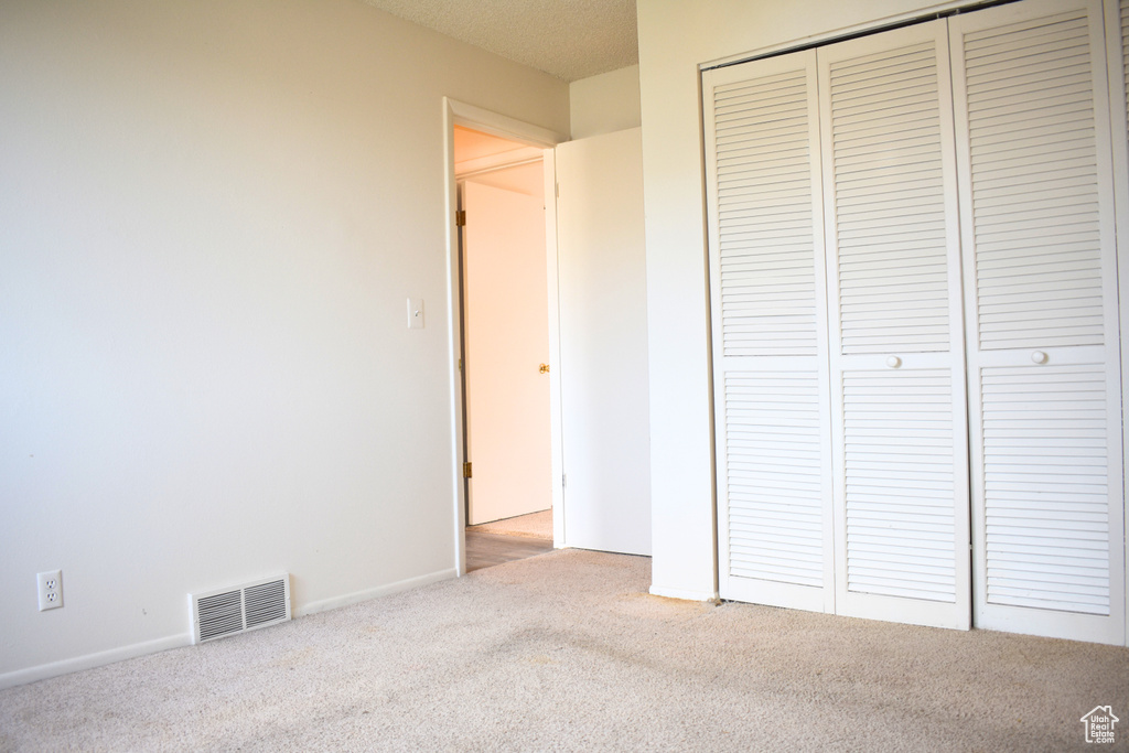 Unfurnished bedroom with carpet flooring, a closet, and baseboards