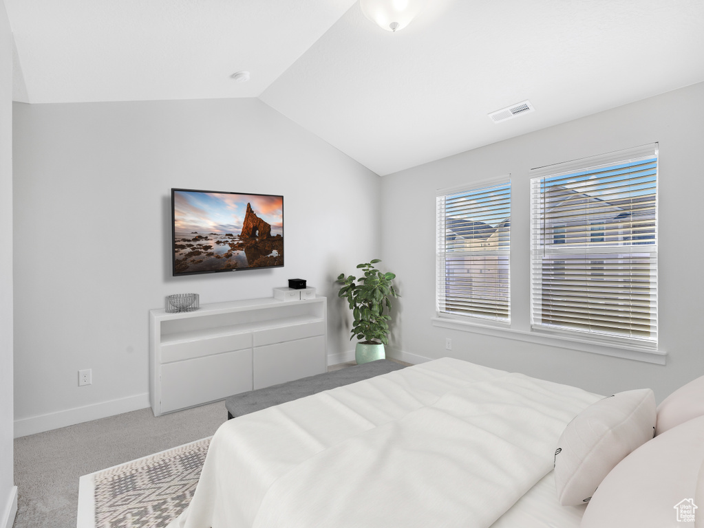 Carpeted bedroom featuring lofted ceiling and baseboards