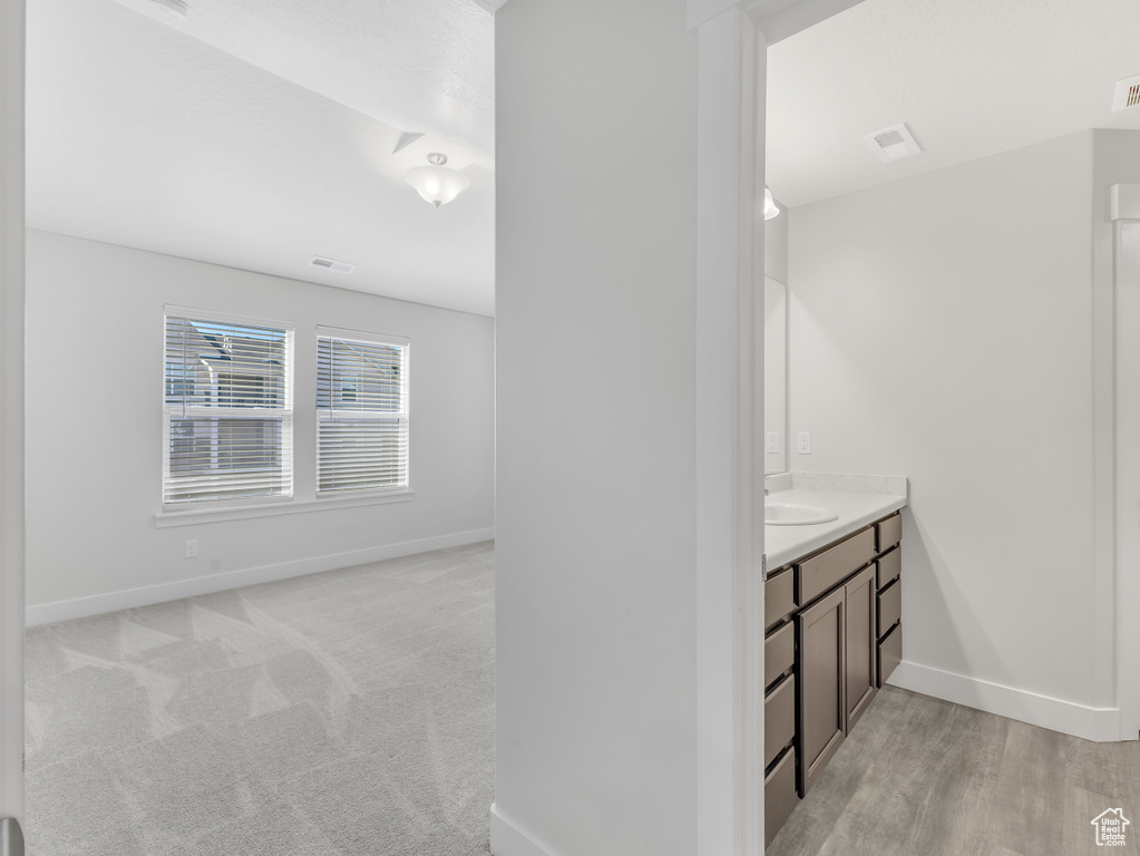 Hall featuring baseboards and a sink