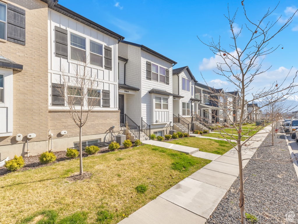 View of building exterior featuring a residential view and cooling unit