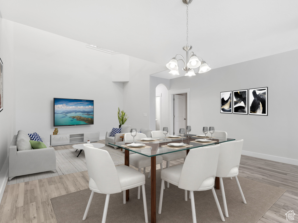 Dining area featuring light wood-style flooring, a chandelier, and baseboards