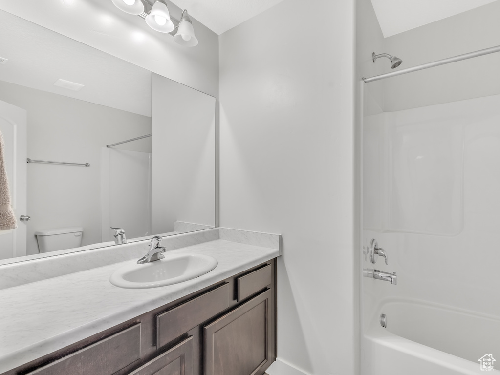 Bathroom with vanity, shower / tub combination, and toilet