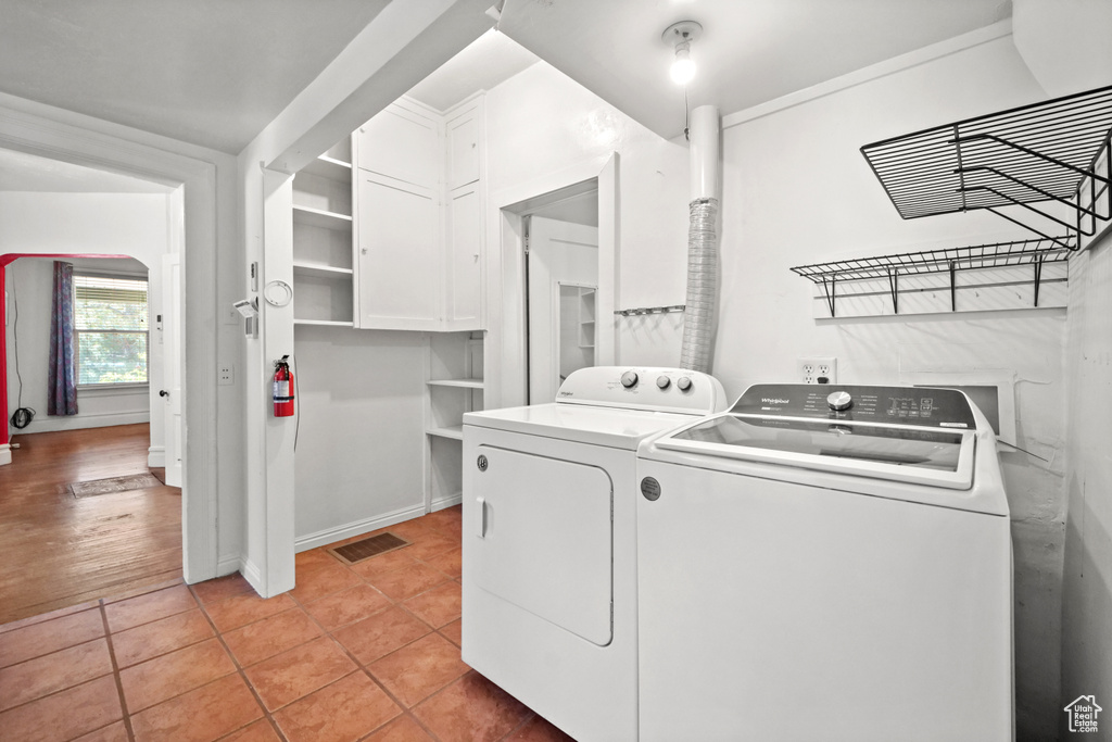 Laundry area with washer and dryer and light tile patterned flooring