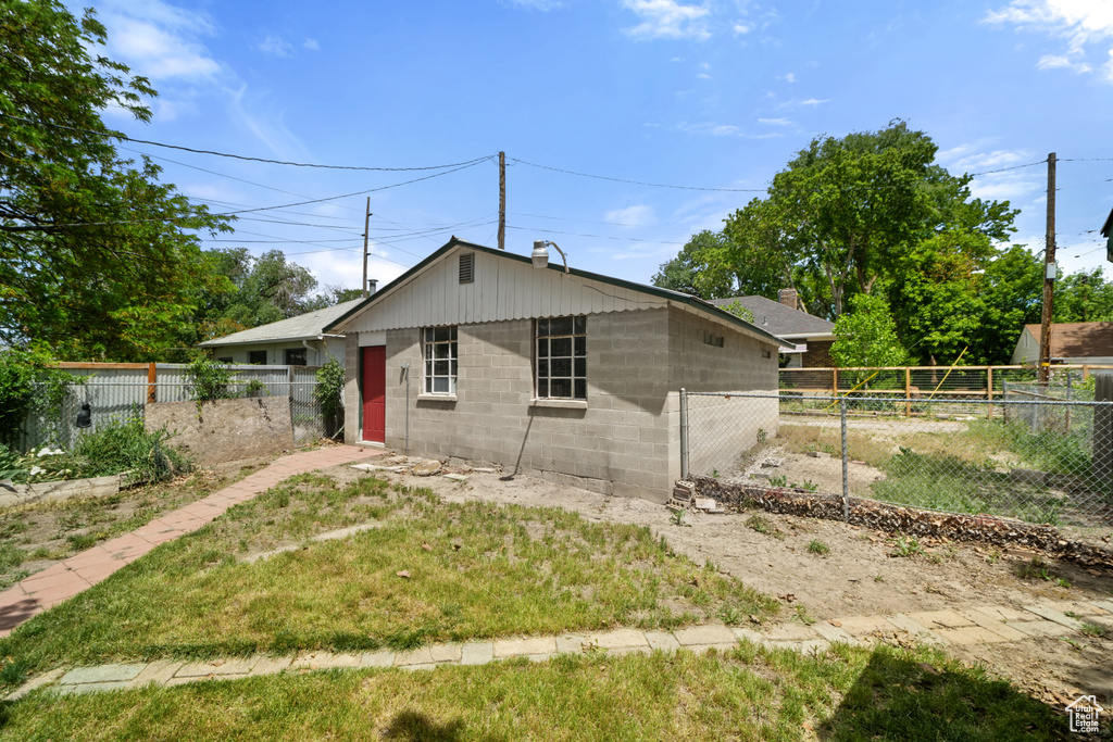 View of front of home with concrete block siding and a chimney