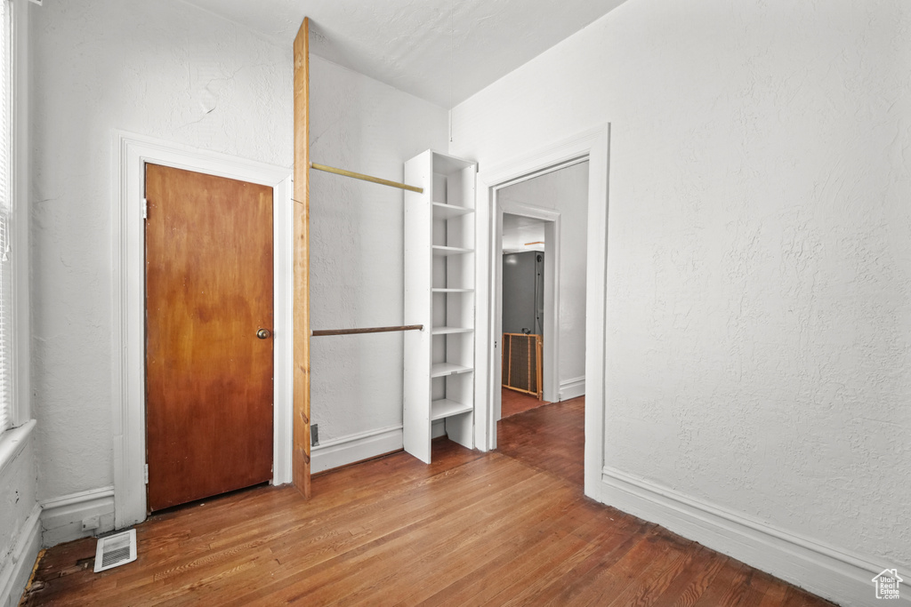 Unfurnished bedroom featuring wood finished floors and baseboards