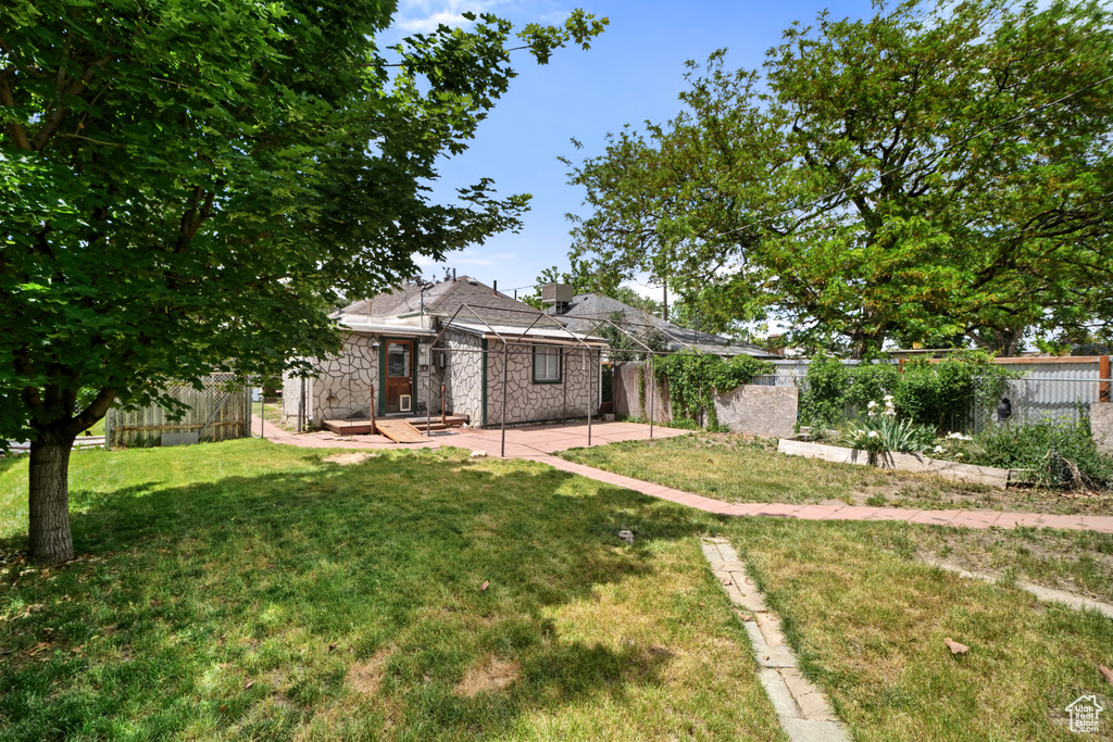 View of front of home with stone siding and a patio