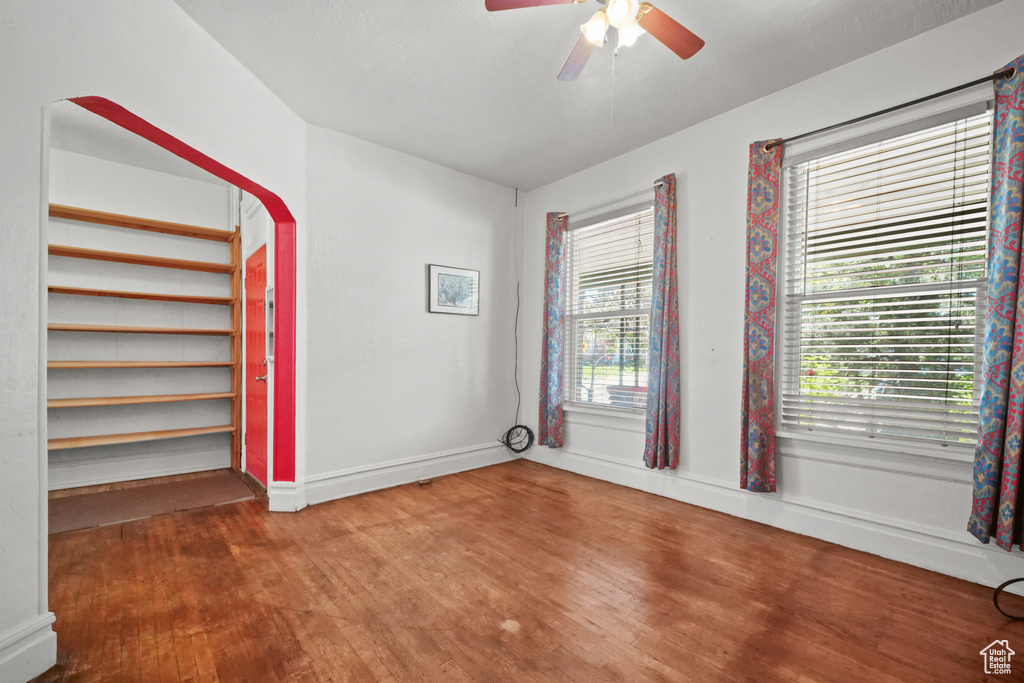 Spare room with wood finished floors, ceiling fan, and baseboards